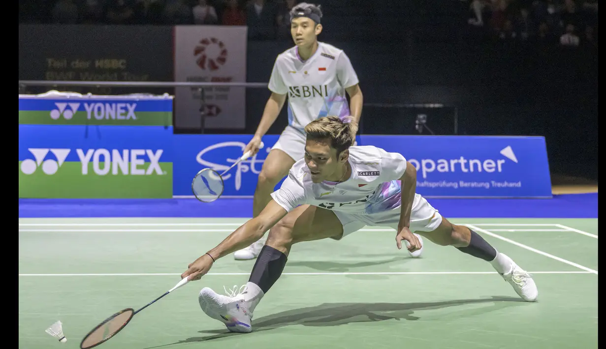 Pemain ganda putra Indonesia, Muhammad Shohibul Fikri yang berpasangan dengan Bagas Maulana berusaha mengembalikan bola drop shot yang dilepaskan pasangan Inggris, Ben Lane/Sean Vendy pada laga final kejuaraan bulu tangkis Swiss Open 2024 di St. Jakobshalle, Basel, Swiss, Minggu (24/3/2024). Bagas/Fikri kalah dua gim langsung 22-24, 26-28 dan gagal menjadi juara. (Keystone via AP Photo/Georgios Kefalas)