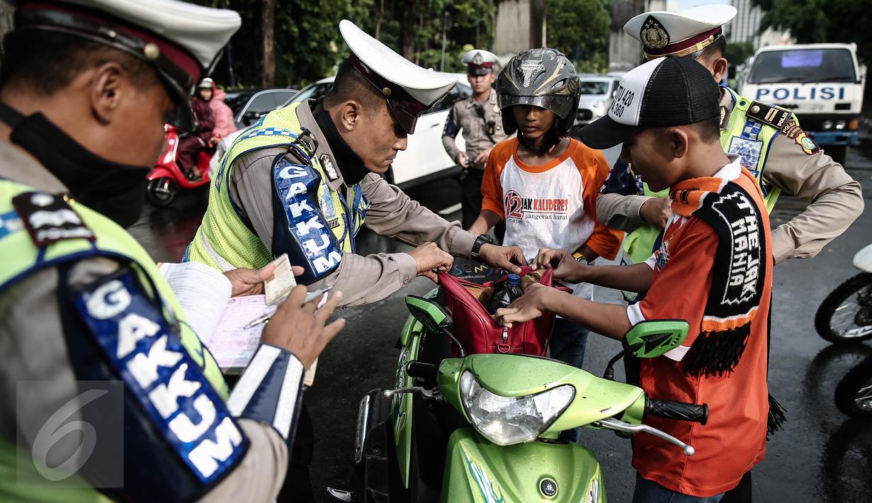 Petugas kepolisian merazia  suporter yang membawa barang berbahaya disekitar kawasan Gelora Bung Karno, Jakarta, Minggu (8/5/2016). Razia tersebut dilakukan untuk mengatisipasi keributan antar supporter. (Liputan6.com/Faizal Fanani)