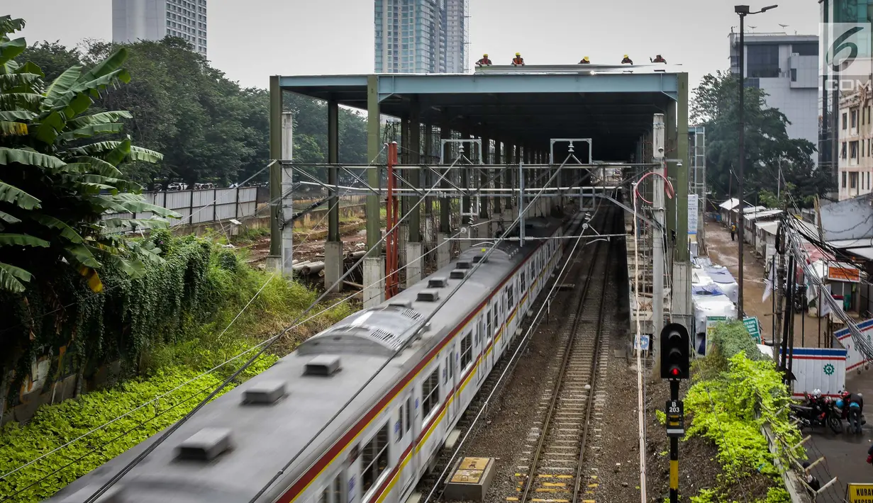 Rangkaian KRL Commuter Line melintas di proyek pembangunan stasiun kereta Bandara Soekarno-Hatta di Stasiun Sudirman Baru, Jakarta, Jumat (19/5). (Liputan6.com/Faizal Fanani)