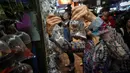 Seorang wanita melihat ikan untuk dijual di Mong Kok Goldfish Market, distrik Kowloon, Hong Kong pada 10 November 2018. Pedagang menggantung ikan hias di dalam plastik bening sehingga pengunjung bisa memilih sendiri ikan yang dimau. (VIVEK PRAKASH/AFP)