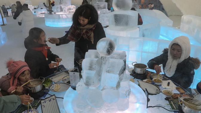 Foto yang diambil 13 Januari 2020 menunjukkan orang-orang menikmati hot pot di meja dan kursi berukir es di dalam igloo selama Festival Es dan Salju Internasional Harbin tahunan. Sementara hampir seluruh perabot di dalam restoran ini seperti meja dan kursi, terbuat dari es. (STR/AFP)