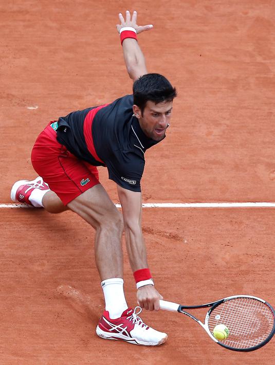 Petenis Serbia, Novak Djokovic melakukan servis ke arah petenis Italia Marco Cecchinato pada perempatfinal Prancis Terbuka 2018 di stadion Roland Garros, Selasa (5/6). Djokovic tumbang 3-6, 6-7, 6-1, dan 6-7 dalam waktu 3 jam 26 menit. (AP /Michel Euler)