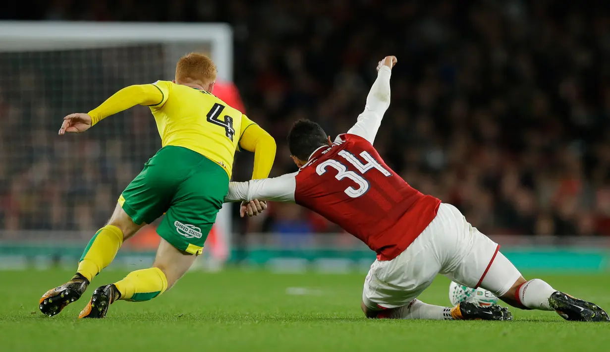 Pemain Arsenal, Coquelin (kanan) berebut bola dengan pemain Norwich City, Harrison Reed pada lanjutan Piala Liga Inggris di Emirates Stadium, Rabu (25/10). Edward Nketiah memborong gol Arsenal saat mengalahkan Norwich City 2-1. (AP/Alastair Grant)