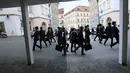 Sejumlah pria mengenakan kostum berwarna hitam berjalan di Brno, Republik Ceko (7/1). Acara International Silly Walk Day ini digelar setiap tahun dan jatuh pada tanggal 7 Januari. (AFP Photo/Radek Mica)