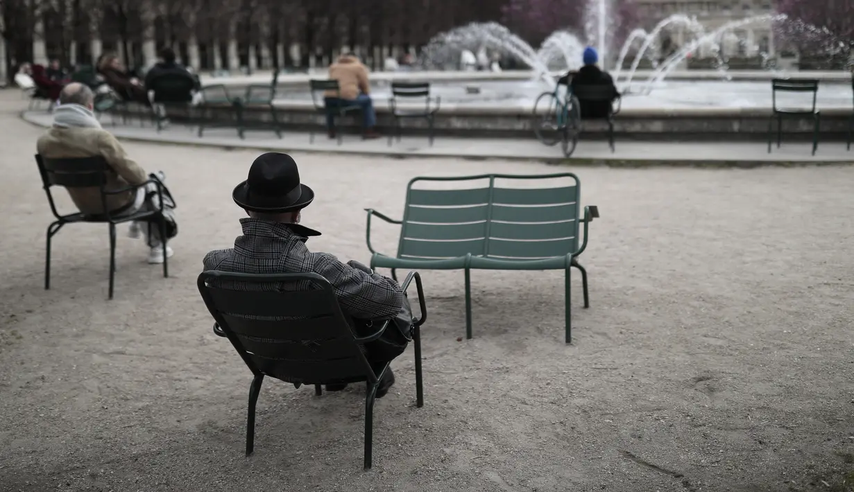 Orang-orang menikmati air mancur di taman Palais Royal di Paris (22/3/2021).Sementara pemerintah Prancis bersikeras bahwa aturan tersebut tidak akan seketat di masa lalu, tindakan tersebut dikritik karena dianggap berantakan. (AP Photo/Lewis Joly)