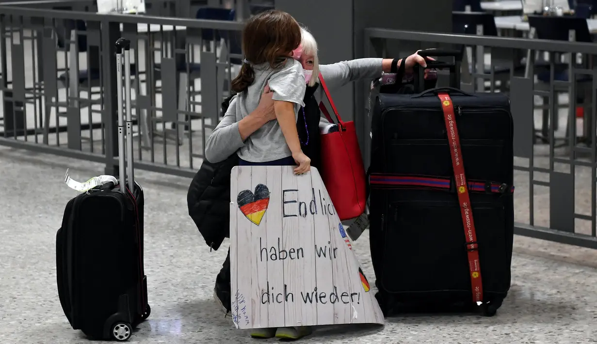 Dorothea White dari Stuttgart, Jerman, memeluk cucu perempuannya saat bertemu kembali di Dulles International Bandara di Chantilly, Virginia, Senin (8/11/2021). AS membuka kembali perbatasannya mulai Senin untuk pengunjung asing, mengakhiri larangan masuk selama 20 bulan. (Olivier DOULIERY/AFP)