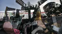Pasien Covid-19 berada di dalam bus sekolah di RSD Wisma Atlet Kemayoran, Jakarta, Kamis (10/6/2021). Meningkatnya jumlah warga yang terpapar Covid-19 menyebabkan antrean ambulans yang hendak masuk ke RSD Wisma Atlet Kemayoran. (merdeka.com/Iqbal S. Nugroho)