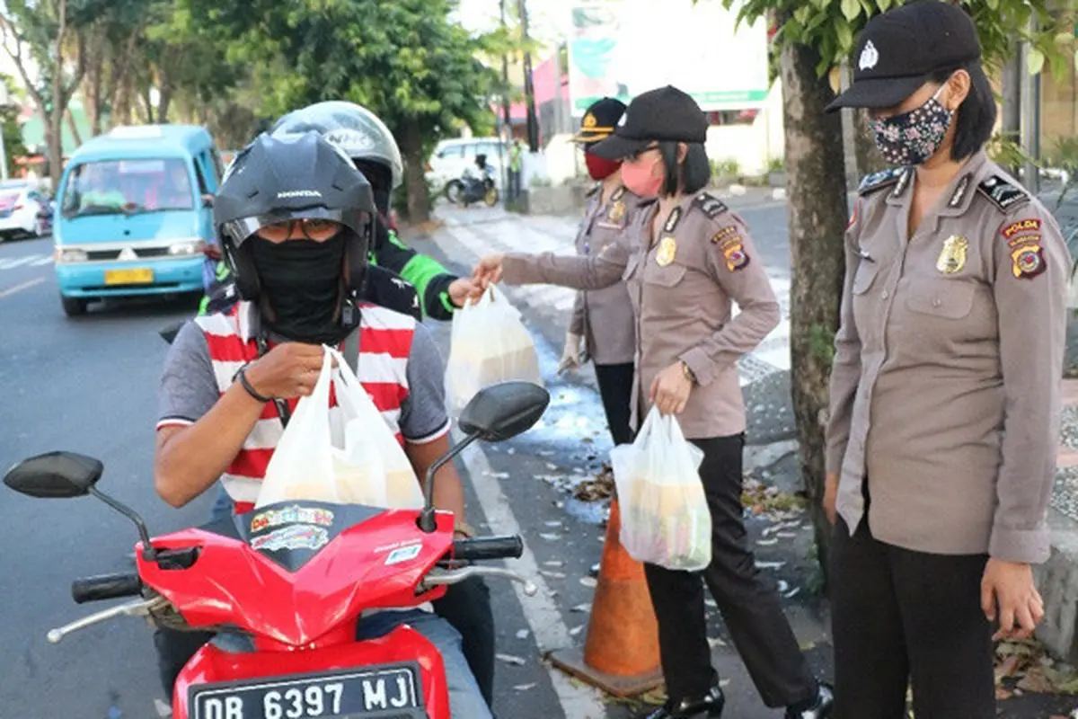 Anggota Polwan saat membagikan takjil secara gratis kepada warga yang menjalankan ibadah pausa di Manado.