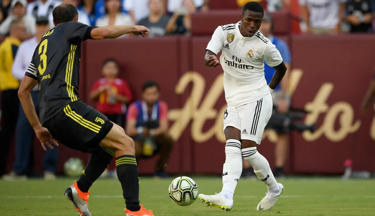 Striker Real Madrid Vinicius Junior mengumpan bola dari kawalan bek Juventus Giorgio Chiellini selama babak kedua pertandingan International Champions Cup (ICC) di Landover, Md (4/8). Madrid menang telak 3-1 atas Juventus. (AP Photo/Nick Wass)