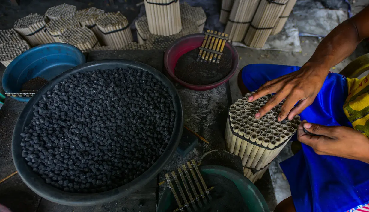 Pekerja menyelesaikan pembuatan petasan di sebuah pabrik di Bocaue, Bulacan, Filipina, Jumat (27/12/2019). Petasan-petasan tersebut akan dijual untuk perayaan Tahun Baru 2020. (Maria TAN/AFP)