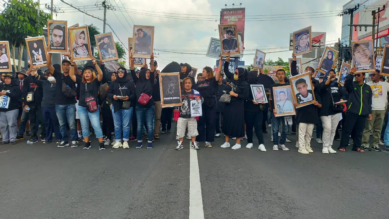 Aremania membawa foto korban tragedi Kanjuruhan dalam aksi damai pada Kamis, 10 November 2022. (Zainul Arifin/Liputan6.com)