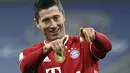 Penyerang Bayern Munchen, Robert Lewandowski berselebrasi usai mencetak gol ke gawang Borrusia Dortmund pada pertandingan lanjutan Bundesliga Jerman di Allianz Arena di Munich, Minggu (7/3/2021). Lewandowski mencetak tiga gol dan mengantar Munchen menang atas Dortmund 4-2. (Sven Hoppe/Pool via AP)