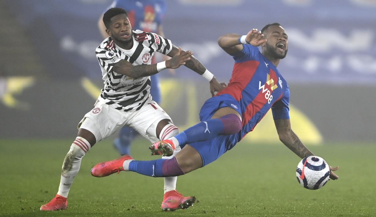Gelandang Manchester United, Fred saat melanggar pemain Crystal Palace Jordan Ayew pada pertandingan lanjutan Liga Inggris di stadion Selhurst Park di London, Inggris, Kamis (4/3/2021). MU bermian imbang atas Crystal Palace 0-0. (Mike Hewitt / Pool via AP)