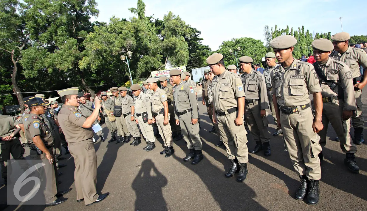 Petugas Satpol PP mengikuti apel gabungan di Monas, Jakarta, Kamis (31/12). Sebanyak 1300 personel gabungan yang terdiri dari polisi, TNI, Pol PP, dan Pramuka dikerahkan untuk mengamankan perayaan malam tahun baru. (Liputan6.com/Immanuel Antonius)
