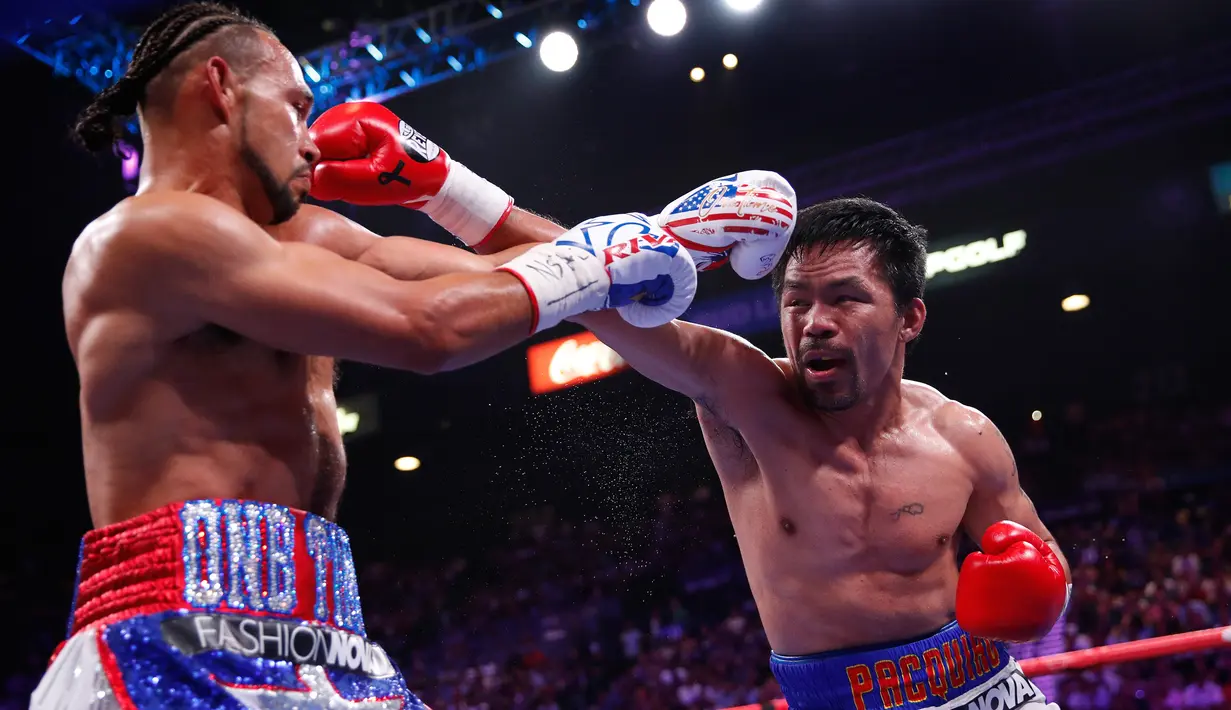 Petinju Manny Pacquiao dan Keith Thurman saling melepaskan pukulan dalam pertarungan gelar tinju Super World kelas Welter WBA di MGM Garden Arena, Las Vegas, Sabtu (20/7/2019). Manny Pacquiao merebut sabuk juara WBA Super kelas welter dengan skor 115-112, 115-112, dan 113-114. (AP/John Locher)