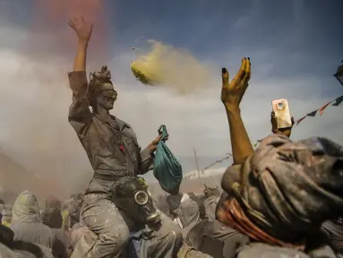 Seseorang melempar tepung berwarna dalam perang tepung selama perayaan 'Ash Monday' di pelabuhan Galaxidi, Yunani, 11 Maret 2019. Pesta itu sebagai pertanda akhir musim karnaval dan awal periode hari Prapaskah sampai Paskah Ortodoks. (ARIS MESSINIS/AFP)