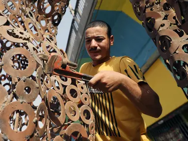 Ibrahim Salah membuat sebuah patung di bengkel kerjanya di Giza, Mesir, pada 5 September 2020. Dua pemuda Mesir berhasil mengubah hobi mereka mendaur ulang barang bekas seperti besi tua menjadi berbagai dekorasi dan furnitur rumah sebagai sumber penghasilan yang stabil. (Xinhua/Ahmed Gomaa)