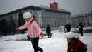Anak-anak perempuan bermain salju di Kim Il Sung Square, Pyongyang, Korea Utara, Minggu (16/12). Korea Utara saat ini mulai memasuki musim dingin. (AP Photo/Dita Alangkara)