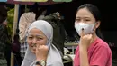 Dua orang perempuan menunjukkan jari-jari mereka setelah memberikan suara dalam pemilihan umum presiden dan legislatif di Jakarta pada tanggal 14 Februari 2024. (BAY ISMOYO/AFP)