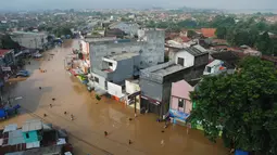 Sejumlah warga melintasi genangan banjir untuk mengungsi di jalan Raya Dayeuhkolot, Kabupaten Bandung, Minggu (13/3). Kawasan Bandung Selatan kembali dilanda banjir akibat luapan Sungai Citarum dan membuat ribuan orang mengungsi. (Timur Matahari/AFP)
