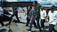 Presiden Joko Widodo (Jokowi) meninjau sejumlah titik yang terdampak bencana gempa dan tsunami di Kota Palu, Sulawesi Tengah, Minggu (30/9). Jokowi yang didampingi sejumlah jajarannya tampak mengenakan jaket loreng khas TNI. (Liputan6.com/Septian Deny)