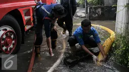 Petugas pemadam kebakaran (damkar) melakukan penyedotan genangan air di Pejaten Raya, Jakarta, Selasa (4/10). Akibat curah hujan yang tinggi menyebabkan sejumlah titik di Jakarta Selatan tergenang air. (Liputan6.com/Yoppy Renato)