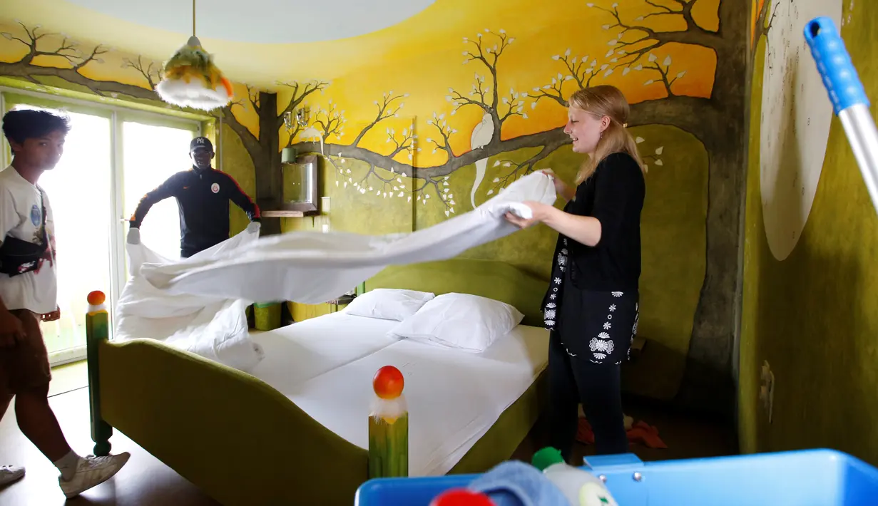 Para sukarelawan merapihkan kamar hotel di "Grandhotel Cosmopolis" di Augsburg, Jerman, (27/7). Hotel ini dapat menampung sekitar 65 imigran dan wisatawan dari seluruh dunia. (REUTERS/Michaela Rehle)