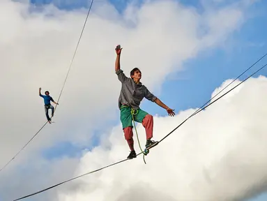 Sebastian Gum Chung Segraves (kanan) dan Daniel Laruelle dari Afrika Selatan berjalan diatas tali saat acara Highline Extreme di puncak Moleson, Swiss (15/9).Berjalan di seutas tali diatas ketinggian ini disebut slackline. (AFP Photo/Michael Buholzer)