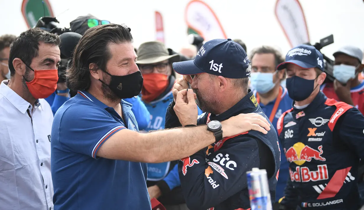Director Rally Dakar, David Castera, memberikan selamat kepada Stephane Peterhanse usai menjadi juara Reli Dakar 2021 di Arab Saudi, Jumat (15/1/2021). Stephane Peterhanse berhasil menambah rekor juaranya menjadi 14 kali juara Reli Dakar. (AFP/Franck Fife)