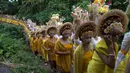 Para wanita yang mengenakan pakaian adat berbaris saat berjalan dalam ritual Hindu Bali bernama Usaba Sri di Karangasem, Bali, Senin, 10 Agustus 2026. (Foto AP/Firdia Lisnawati)