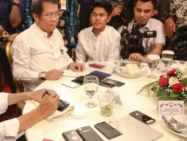 Presiden Joko Widodo menandatangani sejumlah telepon seluler milik wartawan usai berbuka puasa di Istana Negara, Jakarta, Senin (6/7/2015). Sekitar 300 wartawan menghadiri acara buka puasa bersama Jokowi tersebut. (Liputan6.com/Faizal Fanani)