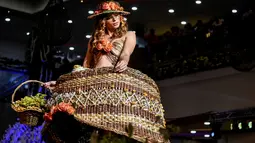 Seorang model memperagakan busana rancangan desainer Kolombia, Laura Campo selama BioFashion Show di Cali  pada 17 November 2018. Ajang ini menampilkan gaun-gaun unik yang terbuat dari tanaman hidup, bunga dan unsur organik lain. (Luis ROBAYO/AFP)