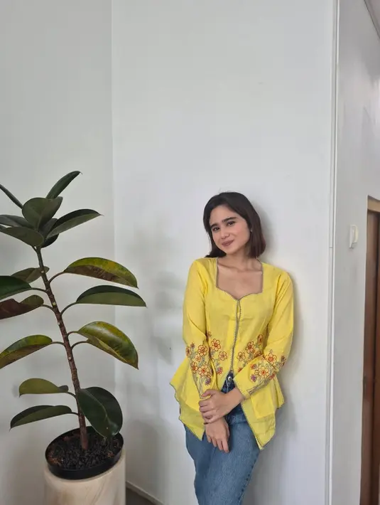 Penampilan Tissa Biani nampak cerah dengan kebaya heartline berwarna kuning dan celana jeans [@tissabiani]