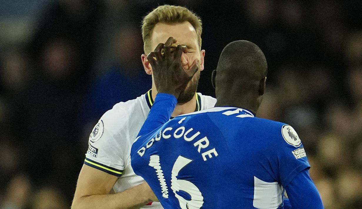 Pemain Tottenham Hotspur, Harry Kane, bersitegang dengan pemain Everton, Abdoulaye Doucoure, pada laga Liga Inggris di Stadion Goodison Park, Selasa (4/4/2023). Spurs masih bersaing ketat dengan Man United dan Newcastle yang sama-sama memiliki 50 poin. (AP Photo/Jon Super)