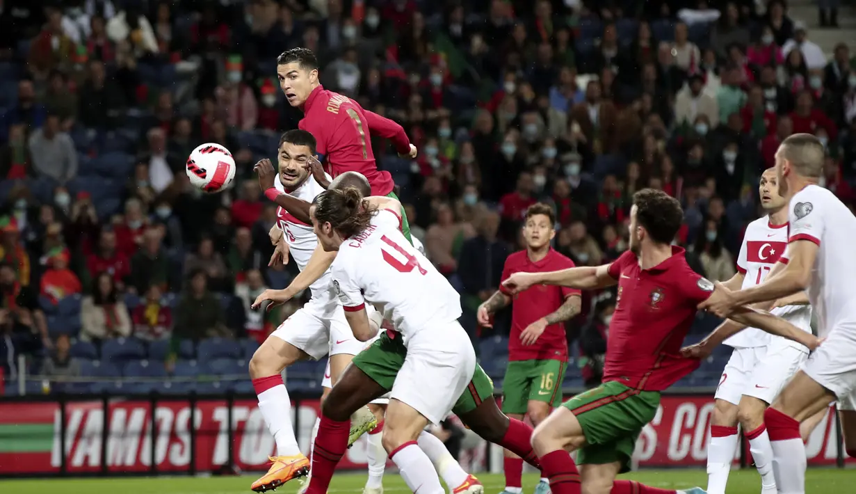 Penyerang Portugal, Cristiano Ronaldo (atas kiri) melakukan sundulan ke gawang Turki selama pertandingan playoff Piala Dunia 2022 di stadion Dragao di Porto, Portugal, Jumat (25/3/2022). Menang 3-1 membuat Timnas Portugal semakin dengan tiket Piala Dunia 2022. (AP Photo/Luis Vieira)