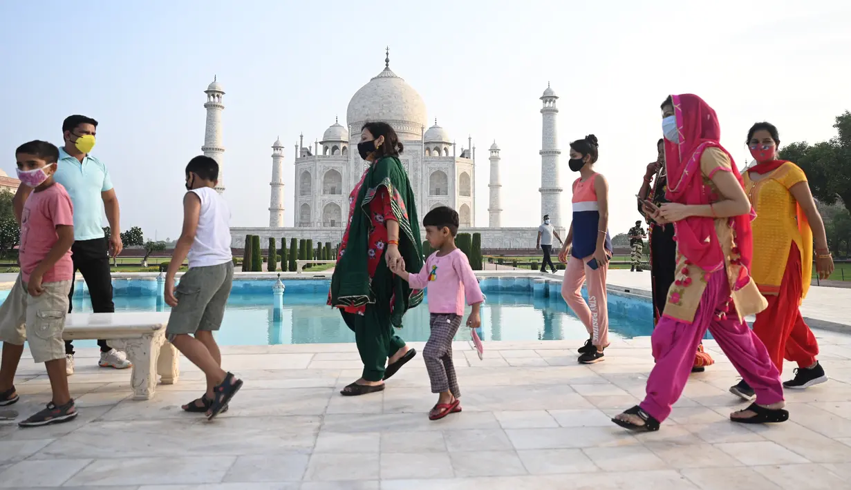 Sejumlah wisatawan mengunjungi Taj Mahal setelah dibuka kembali untuk pengunjung di Agra, Rabu (16/6/2021). Taj Mahal, yang terkenal sebagai ikonik India telah dibuka kembali untuk umum, ketika negara itu mulai melonggarkan pembatasan Covid-19. (Money SHARMA/AFP)
