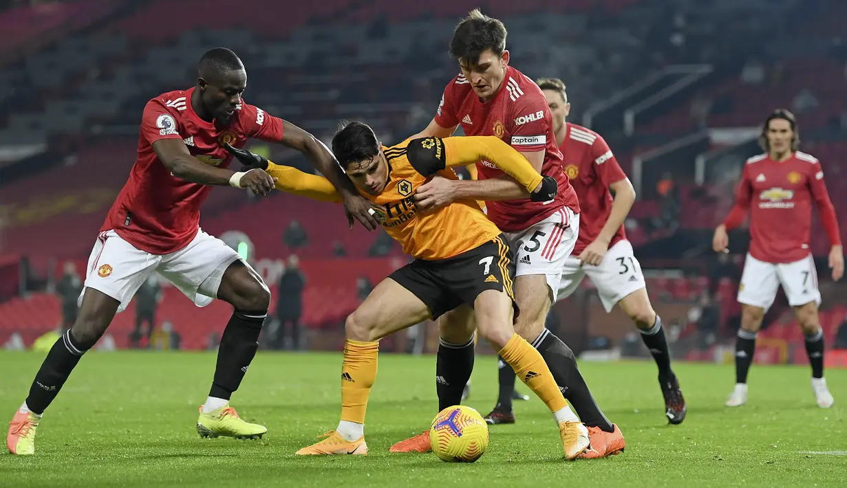 Penyerang Wolverhampton Wanderers, Pedro Neto berusaha mengontrol bola dari kawalan bek Manchester United, Harry Maguire dan Eric Bailly pada pertandingan lanjutan Liga Inggris di Stadion Old Trafford, Rabu (30/12/2020).  (Michael Regan, Pool via AP)