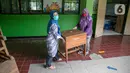 Sejumlah guru memindahkan meja di SDN Kenari 08, Jakarta, Selasa (6/4/2021). Skema yang akan diterapkan adalah pembelajaran tatap muka secara bergantian dengan maksimum 50 persen dari kapasitas ruangan. (Liputan6.com/Faizal Fanani)