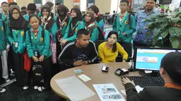 Sejumlah murid SMPN 141 menyaksikan kegiatan pelayanan perbankan di BNI Kantor Cabang Tebet, Jakarta (2/5). Acara ini diikuti oleh 150 siswa dari TK hingga SMA. (Merdeka.com/Arie Basuki)