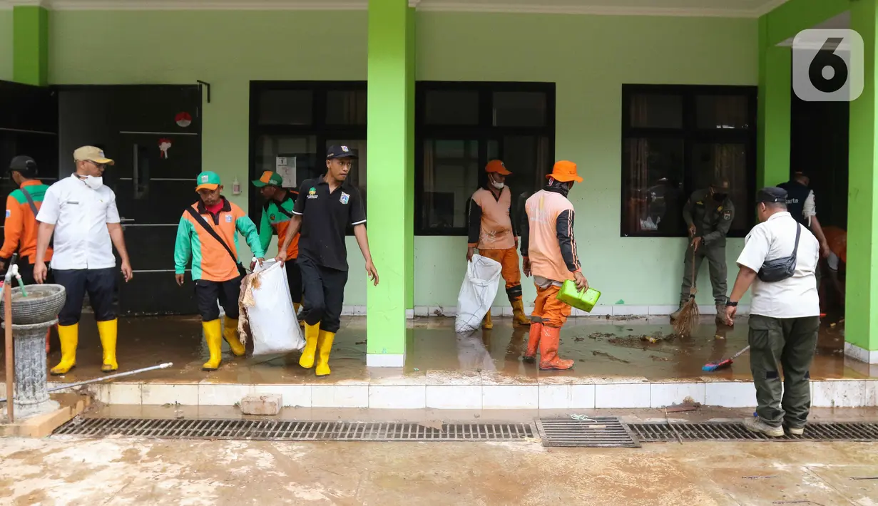 Petugas membersihkan ruangan di MTsN 19 Pondok Labu, Jakarta, Jumat (7/10/2022). Petugas PPSU, Satpol PP, dan Dinas Pemadam Kebakaran membersihkan ruang kelas, kantin, dan fasilitas lainnya usai terendam banjir pada Kamis sore kemarin. (Liputan6.com/Herman Zakharia)