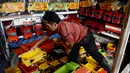 Pedagang mobil kayu merapihkan jualannya di kawasan Kalibata, Jakarta (27/5/2015). Produksi mainan lokal dan tradisional diharapkan mampu bertahan, mengingat pasar bebas Asean yang dimulai Januari 2016 mendatang. (Liputan6.com/Johan Tallo)