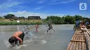 Anak-anak bermain pada aliran Sungai Cisadane di kawasan Keranggan, Setu, Tangerang Selatan, Banten, Minggu (20/3/2022). Cuaca panas terik dimanfaatkan mereka untuk berendam sambil bermain. (merdeka.com/Arie Basuki)