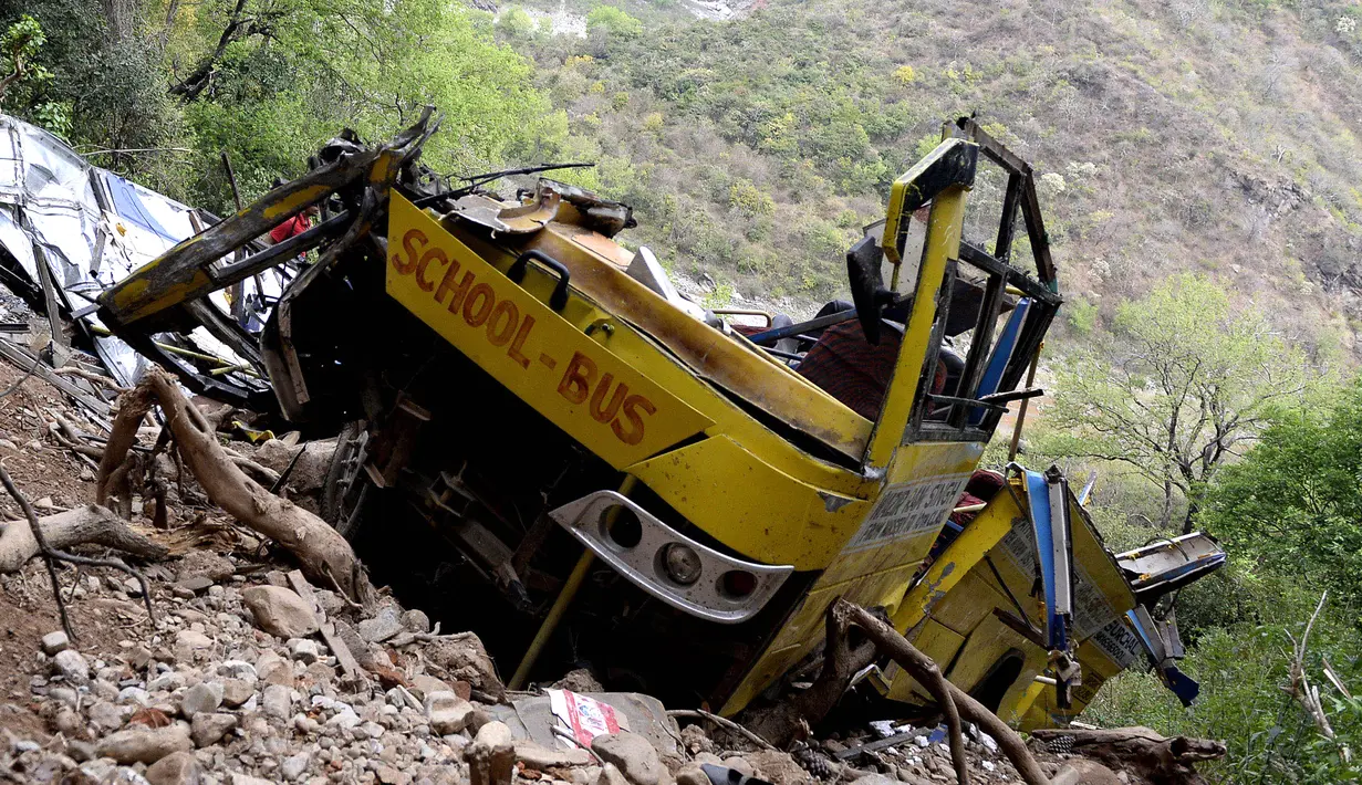 Penampakan bangkai bus sekolah yang rusak akibat masuk jurang di dekat Nurpur, Distrik Kangra, Himachal Pradesh, India, Selasa (10/4). Saksi mata melihat bus tergelincir ketika berbelok dan terperosok ke jurang. (SHAMMI MEHRA/AFP)
