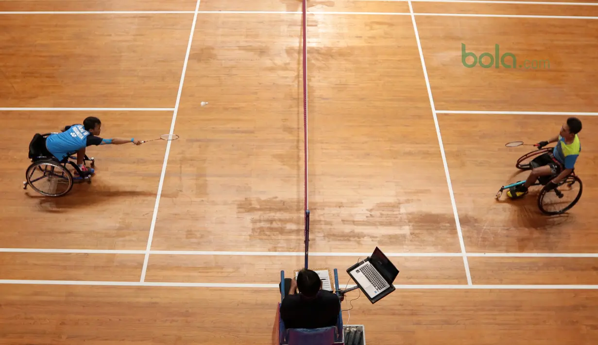 Atlet WC Bulutangkis, Wiwin berusaha menjangkau kok saat melawan  Supriadi (kanan) pada kategori Bulutangkis WH-2 di Istora Senayan, Jakarta (27/6/2018). Supriadi menang 21-11, 21-18. (Bola.com/Nick Hanoatubun)