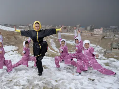 Sima Azimi (tengah) berpose bersama anggota kelompok seni bela diri Wushu Afghanistan di puncak bukit Shahrak Haji Nabi, Kabul, 29 Januari 2017. Sima Azimi adalah wanita pertama dari Afghanistan yang menjadi pelatih seni bela diri Wushu (WAKIL KOHSAR/AFP)
