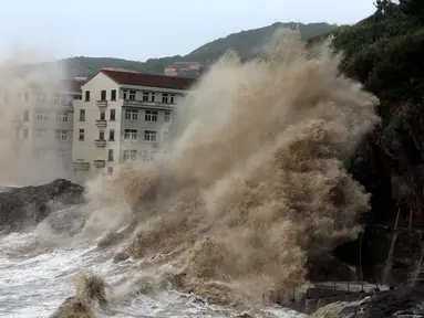 Pemandangan saat ombak besar yang diakibatkan terpaan Topan Maria menghantam tembok di pantai dekat Wenling, Provinsi Zhejiang, China, Rabu (11/7). (AFP)