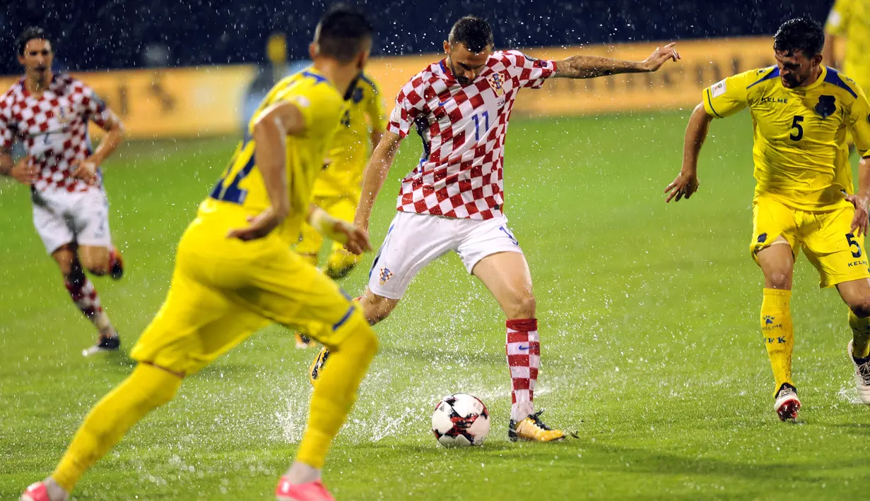 Pemain Kroasia, Marcelo Brozovic (tengah) berusaha menendang bola diatas genangan air pada laga Grup I kualifikasi Piala Dunia 2018 di Stadion Maksimir, Zagreb, (2/9/2017).  Laga tersebut diberhentikan wasit karena stadion penuh genangan air. (AFP/ STR)