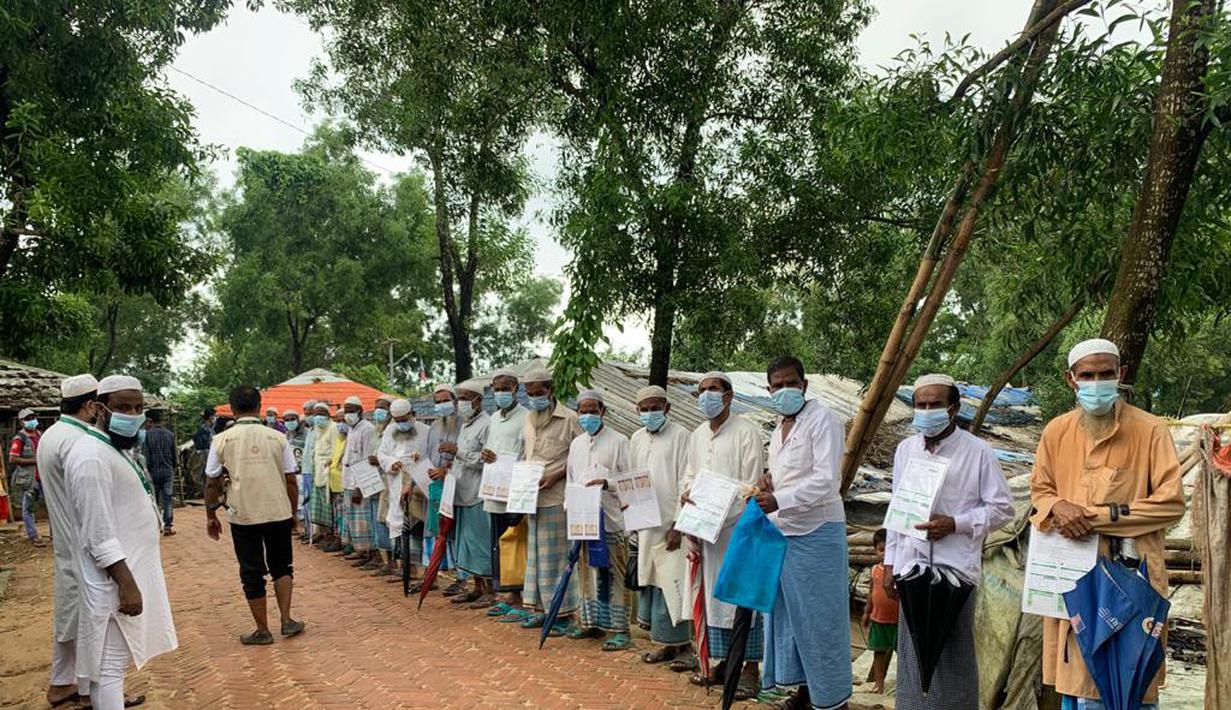 Pengungsi Rohingya menunggu untuk divaksinasi COVID-19 di Cox's Bazar, Bangladesh (10/8/2021).  Pemerintah Bangladesh dan lembaga bantuan mulai memvaksinasi pengungsi Rohingya pada Selasa ketika gelombang virus meningkatkan risiko kesehatan di kamp-kamp pengungsian. (AP Photo/ Shafiqur Rahman)