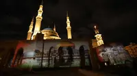 Masjid Al-Amin dan Katedral Christian Maronite saat diterangi cahaya bergambar masjid al-Aqsa dan gereja Makam Suci di Kota Tua Yerusalem di Beirut, Lebanon, (7/12). (AFP Photo/Anwar Amro)