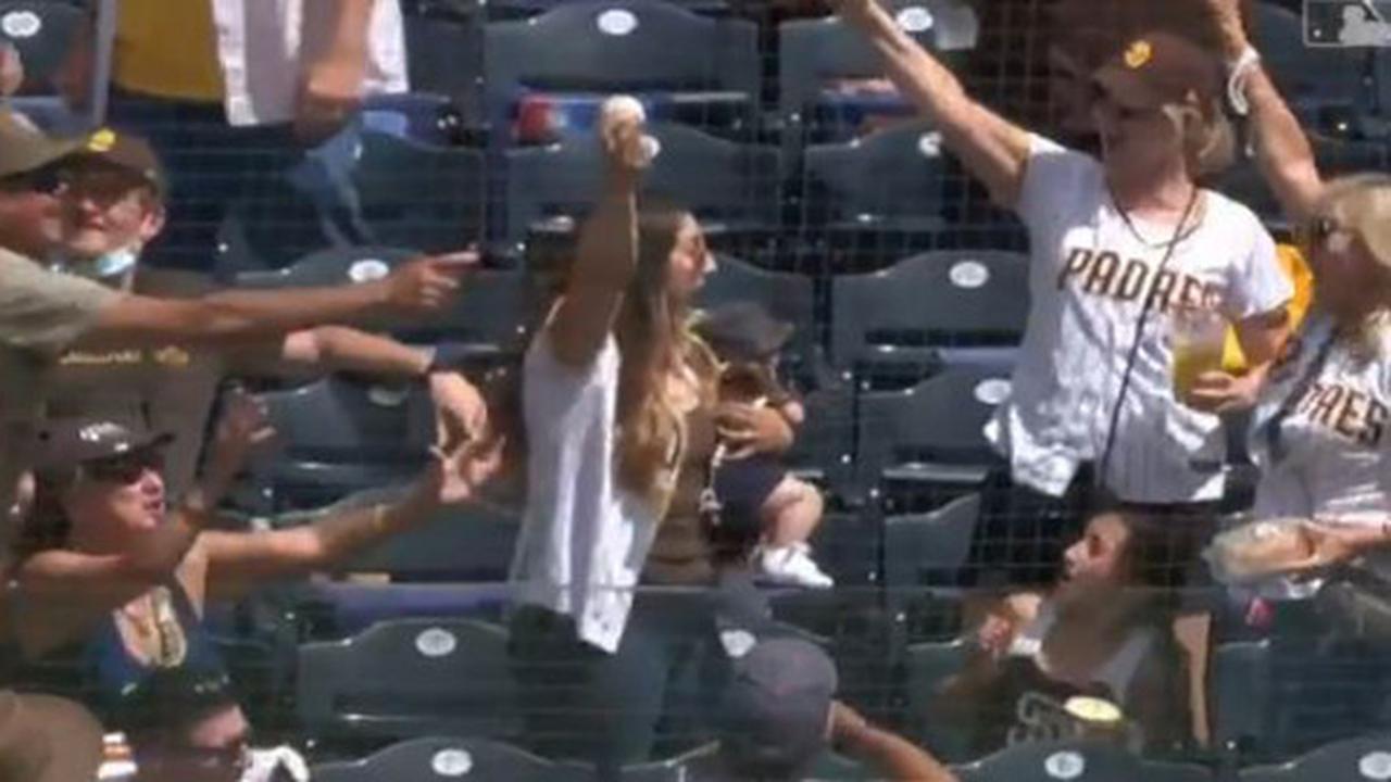 Seorang ibu berhasil menangkap bola sembari menggendong anaknya